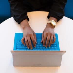 man’s hands typing on a laptop