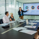 AI strategy meeting with a team reviewing data dashboards and market share charts on a presentation screen, showing collaborative planning and data-driven decision making.